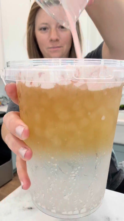 Gallery image 2: Person pouring a pink liquid into a clear container in a kitchen setting